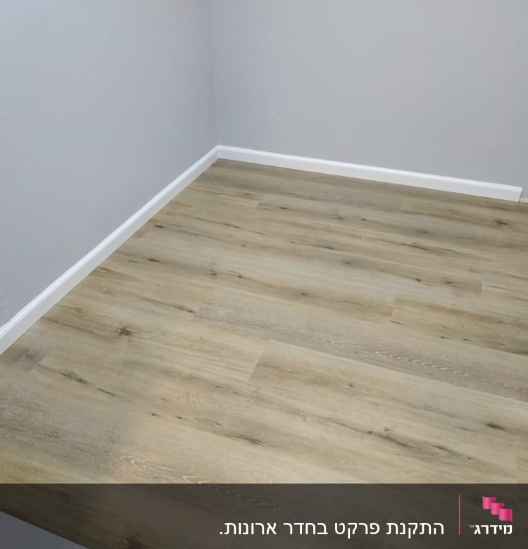 רצפת פרקט עץ בהירה בחדר עם קירות אפורים